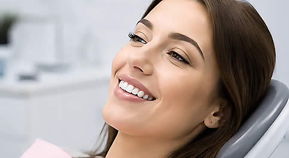A smiling patient reclining in the dental chair