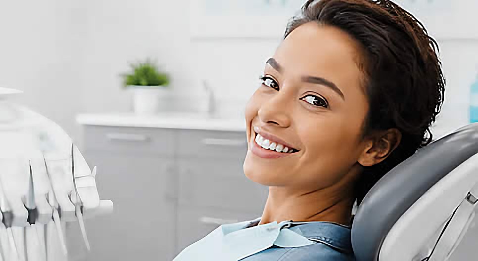A smiling patient reclining in the dental chair