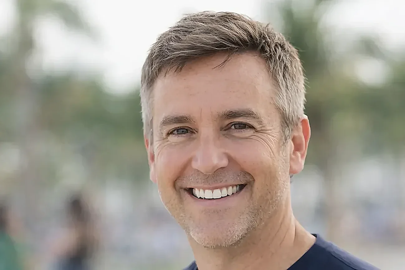 A middle-aged man smiling outdoors