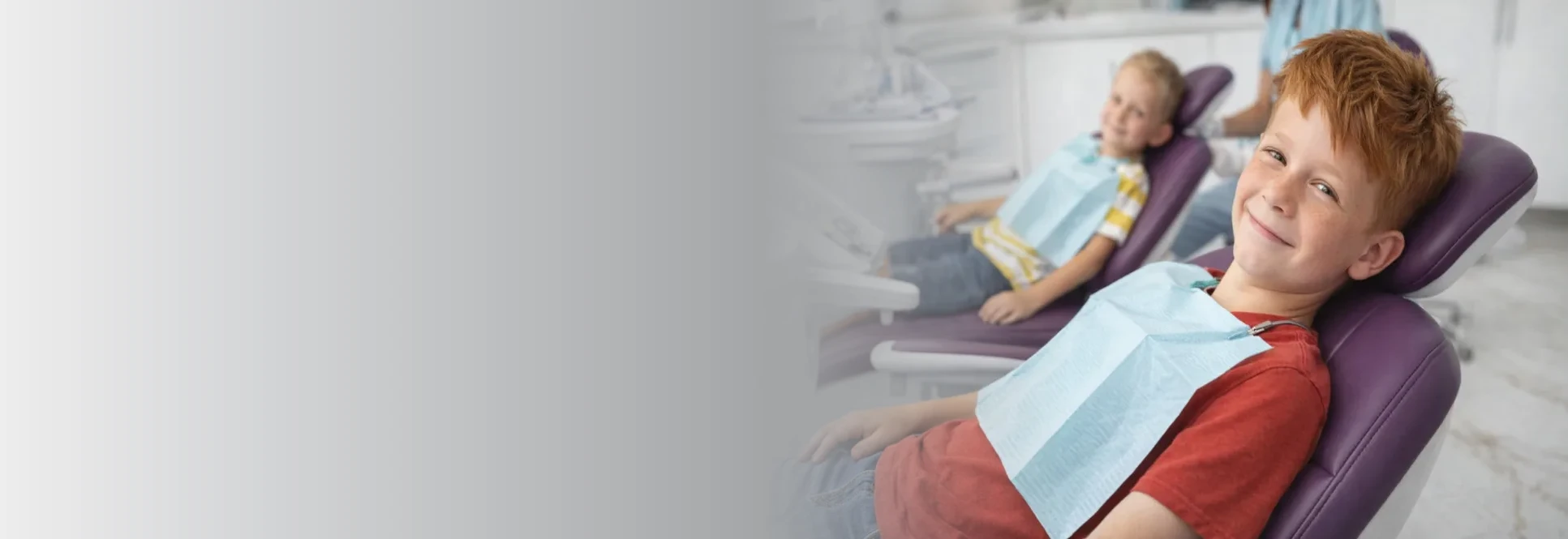 A smiling boy seated in the dental chair
